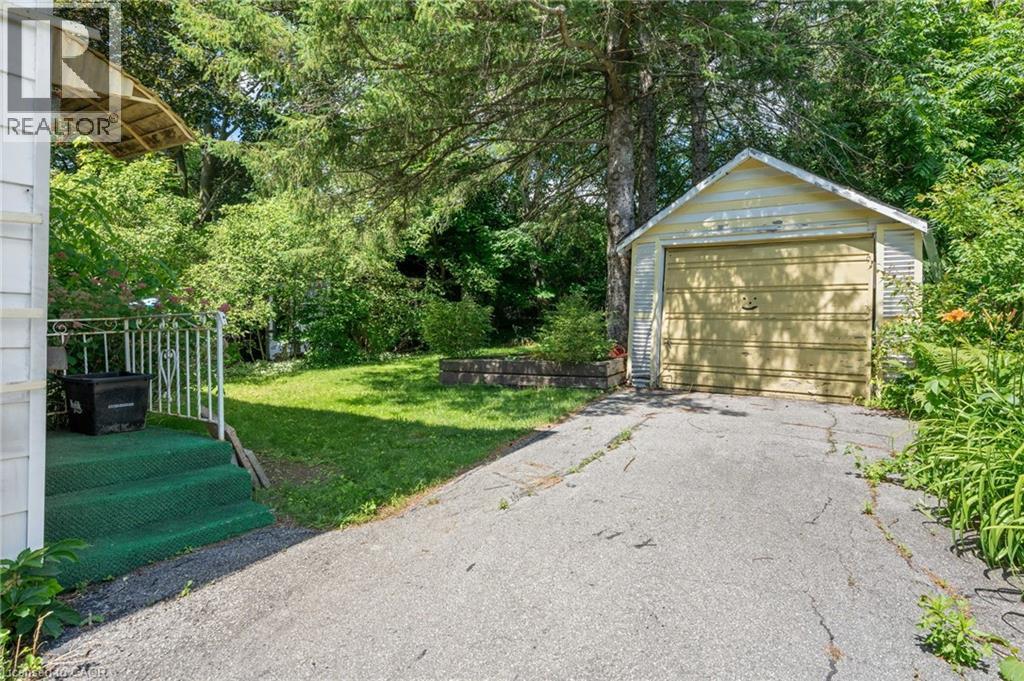 Detached garage with horizontal siding and a single garage door, complemented by a paved driveway - 35 Basil Avenue, Simcoe, ON