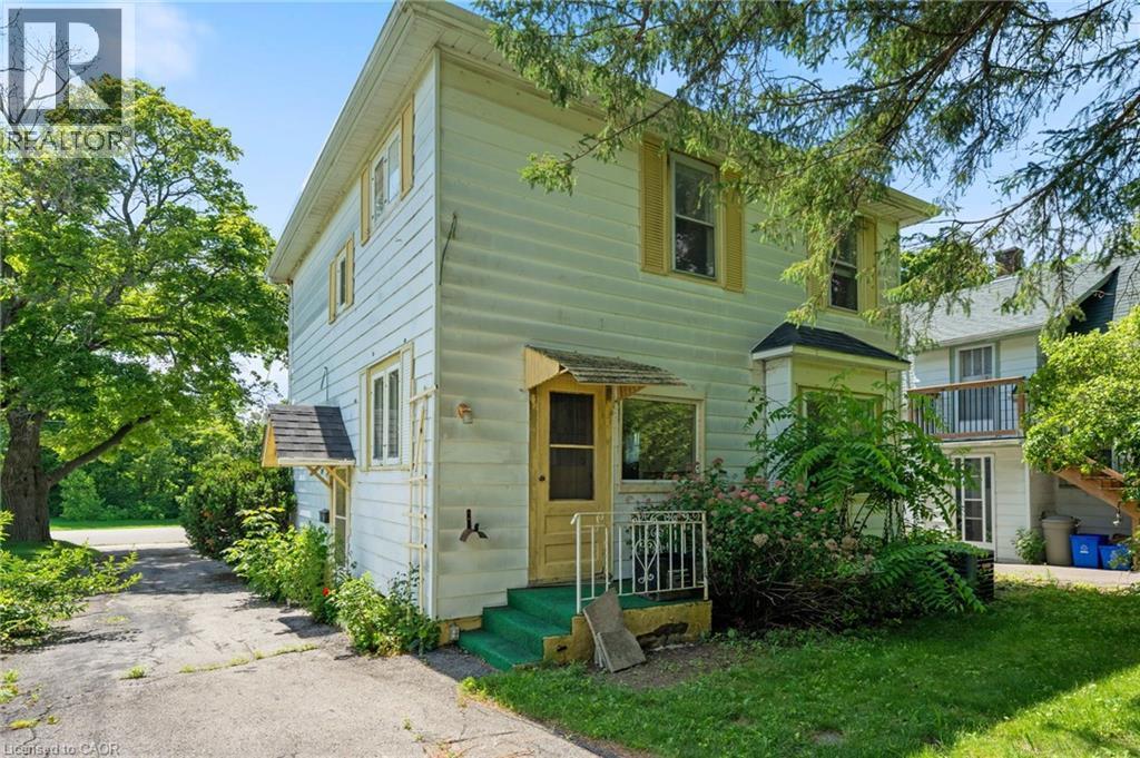 Two-story exterior featuring light-colored siding and yellow trim accents - 35 Basil Avenue, Simcoe, ON