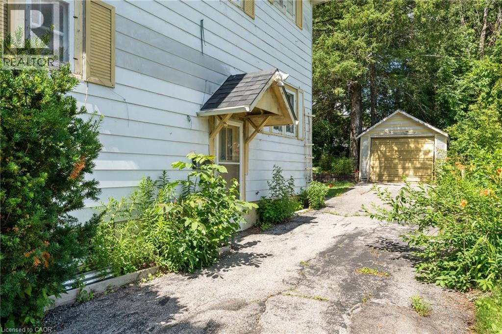 Asphalt driveway extending to a detached single-car garage - 35 Basil Avenue, Simcoe, ON