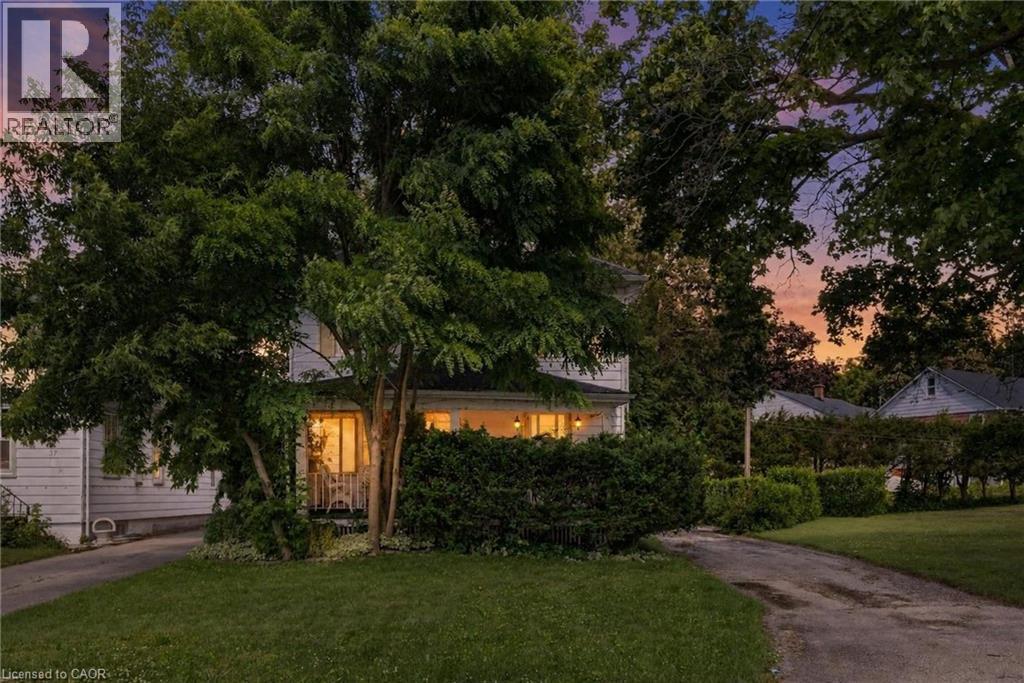 Two-story residence featuring white siding and a covered front porch - 35 Basil Avenue, Simcoe, ON