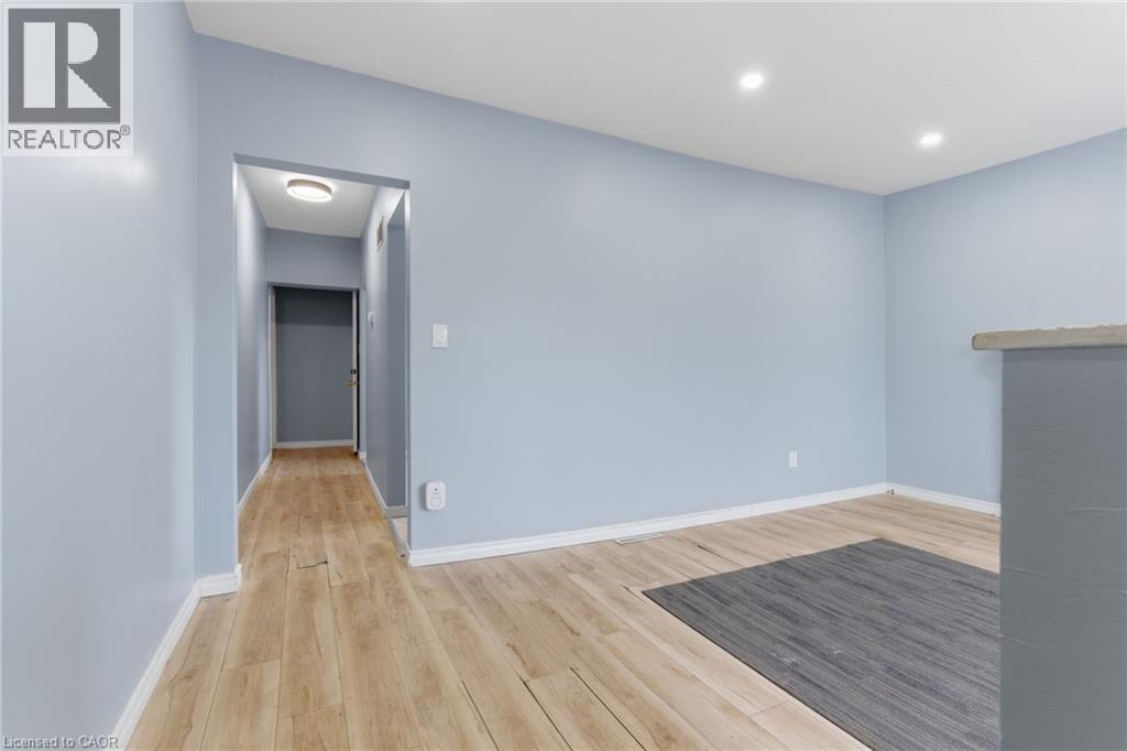 Interior space featuring light blue walls and wood-finish flooring - 880 Lawrence Road, Hamilton, ON