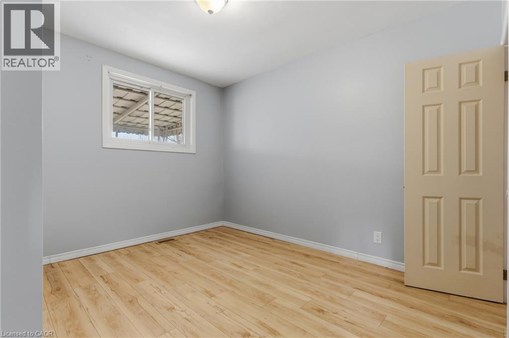 Spacious room with wood-finish flooring, light gray walls, and white trim - 880 Lawrence Road, Hamilton, ON