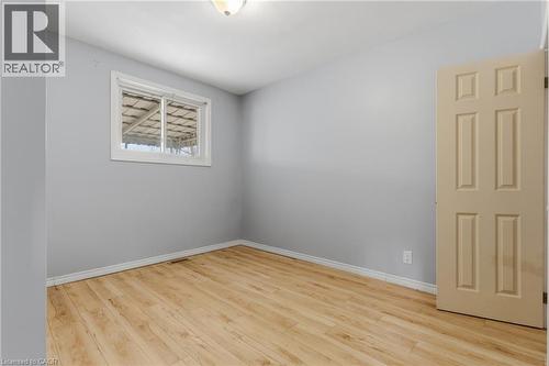 Spacious room with wood-finish flooring, light gray walls, and white trim - 880 Lawrence Road, Hamilton, ON 