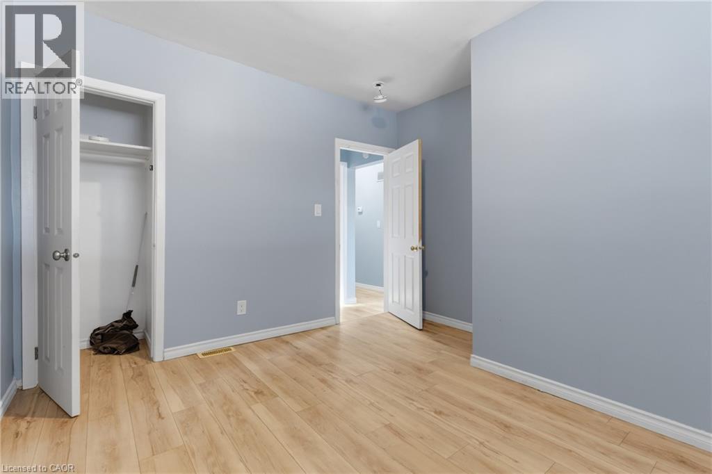 Light wood-finish flooring complements the light blue wall tones - 880 Lawrence Road, Hamilton, ON