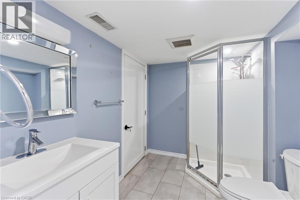 Bathroom featuring a vanity with an integrated sink, polished chrome faucet, and a framed mirror - 880 Lawrence Road, Hamilton, ON