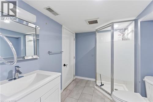 Bathroom featuring a vanity with an integrated sink, polished chrome faucet, and a framed mirror - 880 Lawrence Road, Hamilton, ON 