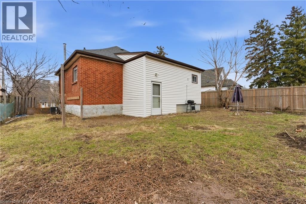 Fenced backyard featuring mixed siding and brick exterior - 880 Lawrence Road, Hamilton, ON