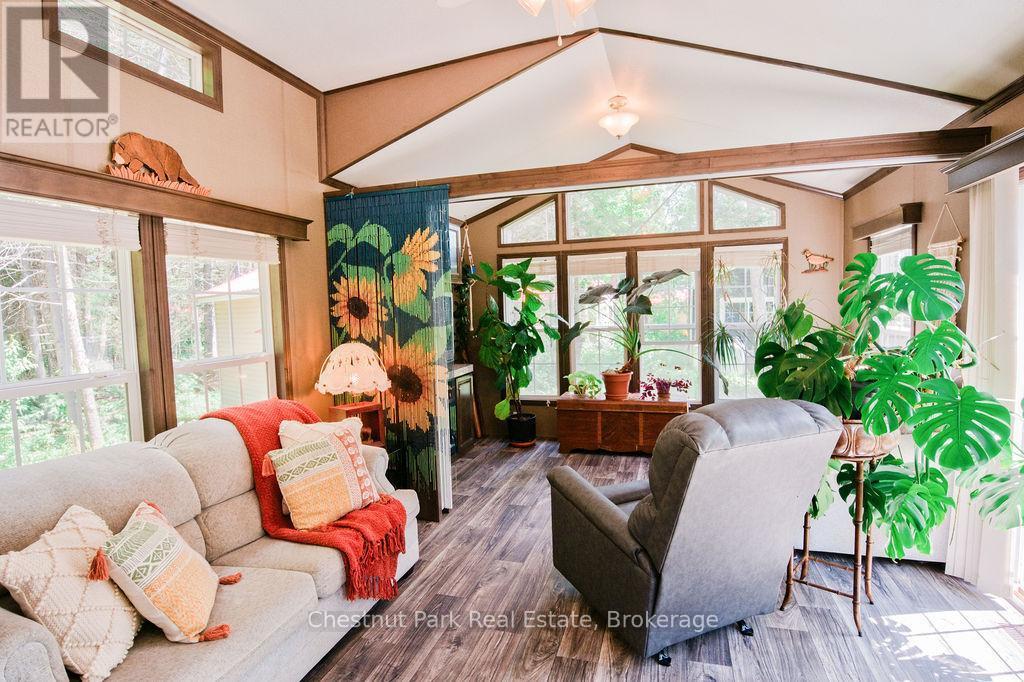 Livingroom - Bifold door behind sunflowers - Unit 1 - 98 North Shore Road, Kearney (Proudfoot), ON