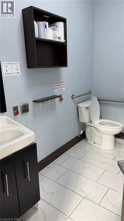 Restroom featuring a wall-mounted shelving unit, contemporary vanity with integrated sink, and horizontal grab bars - 9 Beaumaris Drive Unit# B4, Brampton, ON