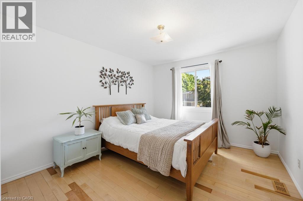 Light-filled room featuring wood-finish flooring, a double-pane window, and a ceiling-mounted light fixture - 14 Gateway Drive, Guelph, ON