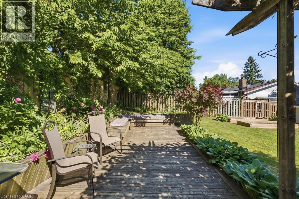 Expansive wooden deck with integrated planter boxes and surrounding mature trees - 14 Gateway Drive, Guelph, ON