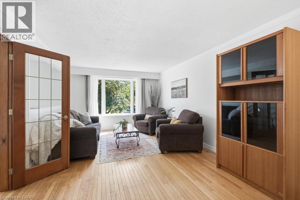 Living area featuring light wood-finish flooring, a large bay window, and crown molding - 14 Gateway Drive, Guelph, ON