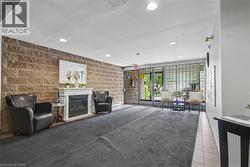 Inviting lobby area featuring a stone accent wall, decorative fireplace with white mantel, recessed lighting, and a glass-paneled entrance -