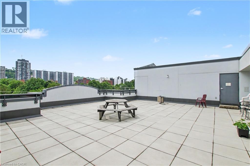 Expansive rooftop deck featuring large format square pavers and partial perimeter walls - 175 Hunter Street E Unit# 401, Hamilton, ON - Outdoor