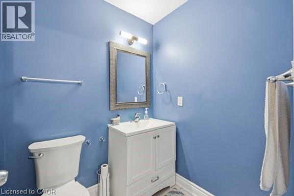 Bathroom with a white vanity and integrated sink, framed mirror, and chrome fixtures - 16 Harrison Avenue, Hamilton, ON
