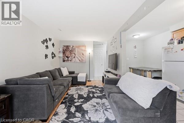 Open-concept living space featuring wood-finish flooring, recessed lighting, and a neutral wall color palette - 16 Harrison Avenue, Hamilton, ON