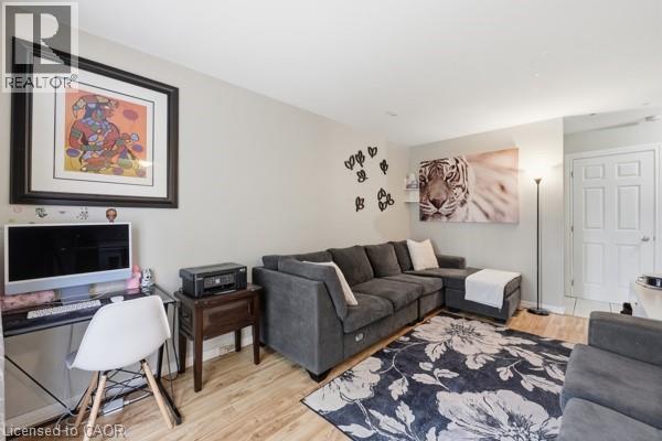 Living area with light wood-finish flooring and neutral wall tones - 16 Harrison Avenue, Hamilton, ON