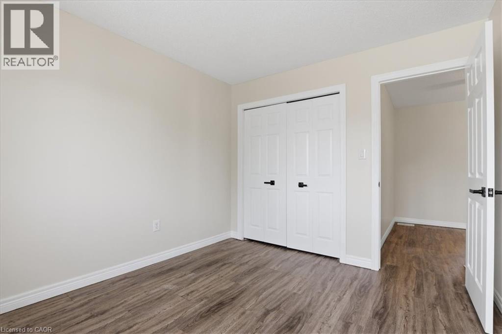 Neutral-toned walls complement wood-finish flooring throughout this room - 43 Decaro Crescent, Cambridge, ON