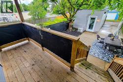 Multi-level wooden deck with natural wood railings, overlooking a concrete patio area -