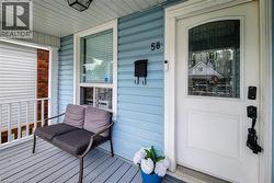 Covered porch featuring light blue siding and grey floorboards -