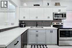 Contemporary kitchen featuring two-tone cabinetry with matte black hardware -