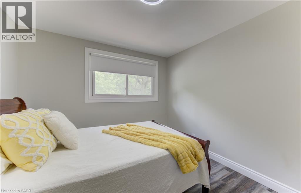 Wood-finish flooring with white baseboards and neutral wall paint - 619 Forest Hill Drive, Kitchener, ON