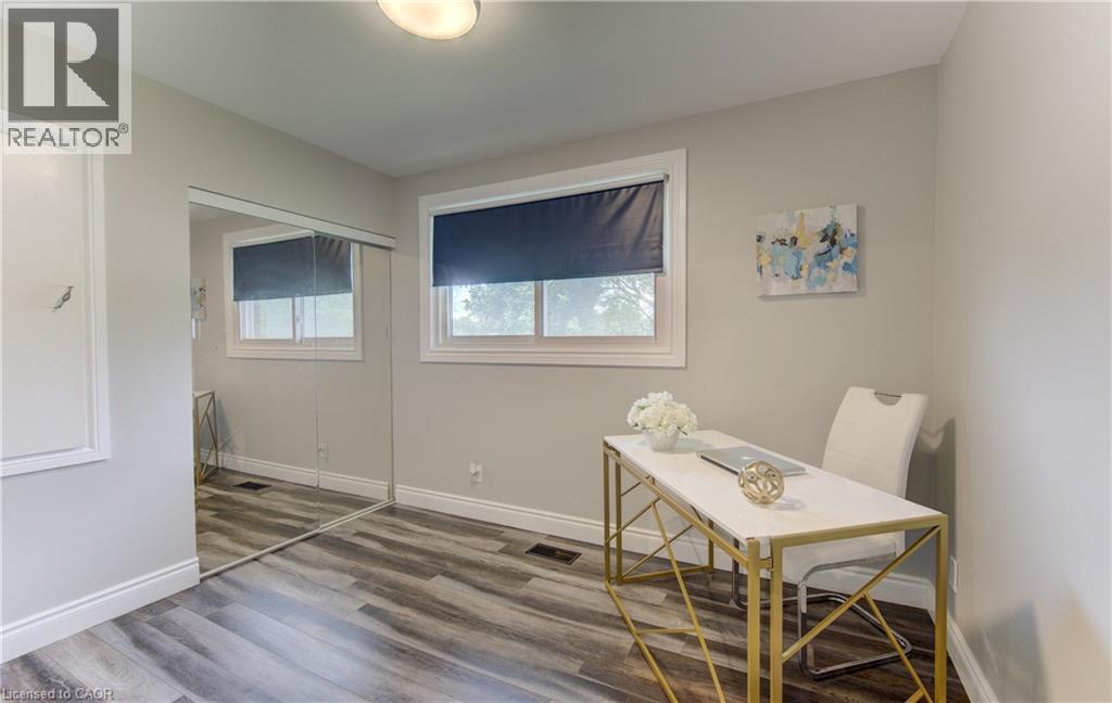 Room featuring wood-finish flooring, light grey walls, and white trim - 619 Forest Hill Drive, Kitchener, ON