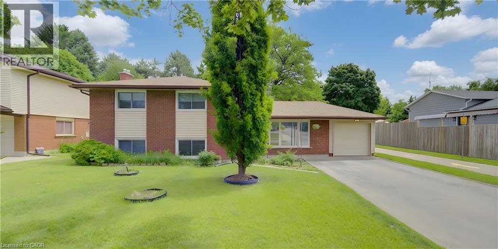 Brick and siding exterior featuring a single-car garage and a paved driveway - 619 Forest Hill Drive, Kitchener, ON