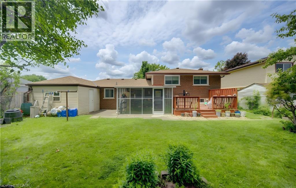 Spacious backyard featuring a multi-level wood deck, a screened-in porch, and a detached storage shed - 619 Forest Hill Drive, Kitchener, ON