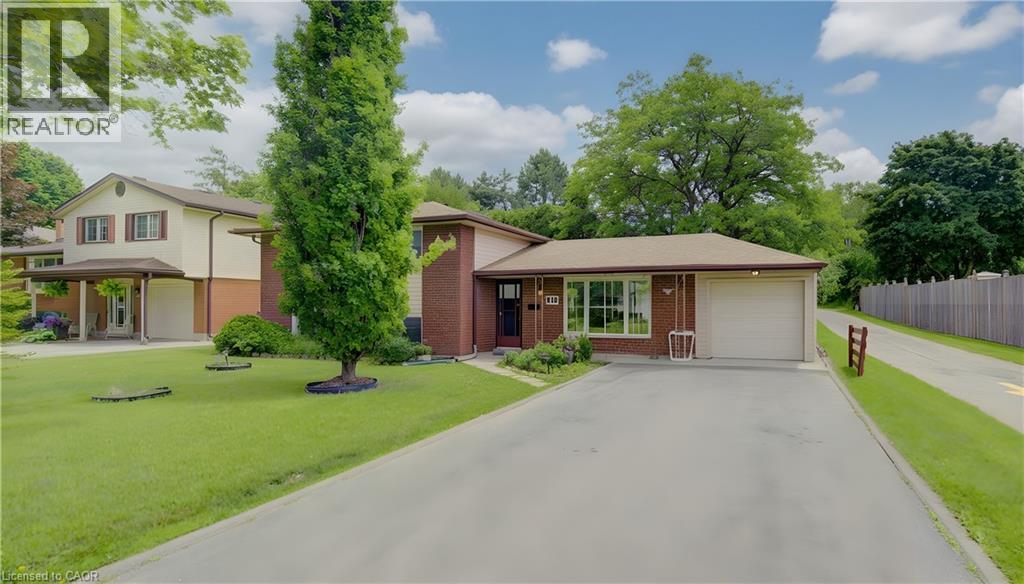 Brick-clad residence featuring an attached single-car garage and a paved driveway - 619 Forest Hill Drive, Kitchener, ON