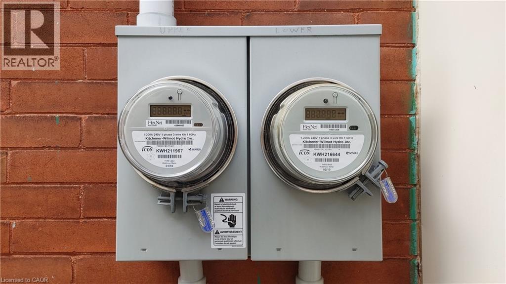 Dual utility meters mounted on a brick exterior wall - 30 Hohner Avenue, Kitchener, ON