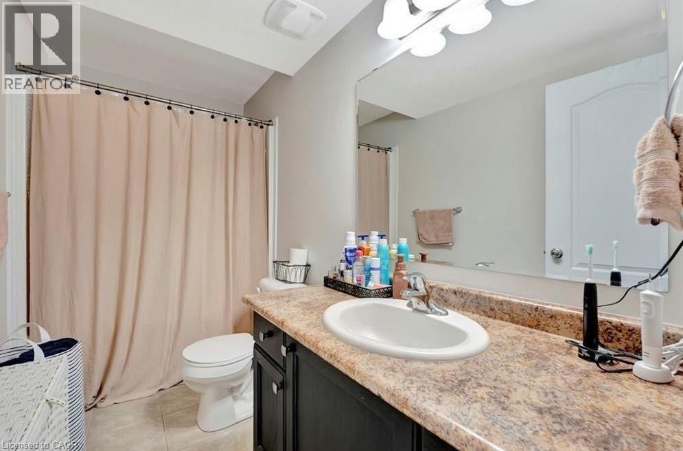 Bathroom featuring a dark wood vanity with a speckled countertop, an integrated oval sink, and chrome faucet - 236 Rachel Crescent Unit# E, Kitchener, ON