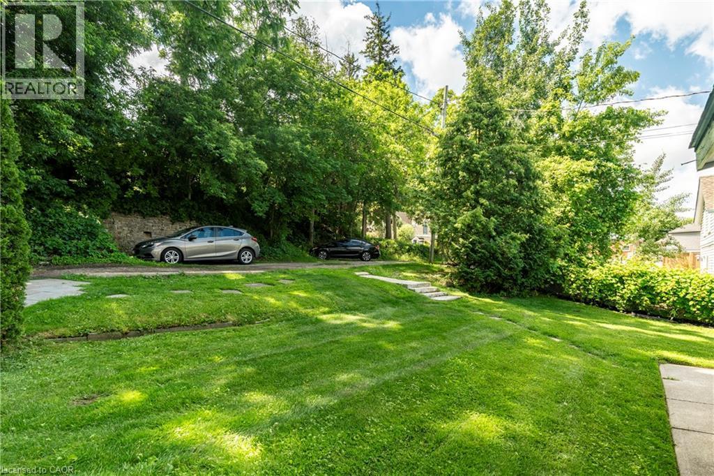 Expansive lawn area with a gentle slope and mature trees - 66 Queen Street W, Cambridge, ON
