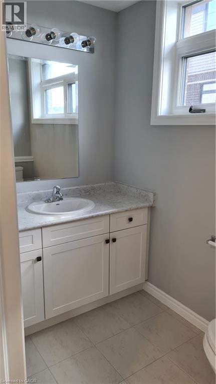 Bathroom vanity with white shaker-style cabinetry, a built-in sink, and a light-toned countertop - 42 Wheat Lane Unit# 42, Kitchener, ON