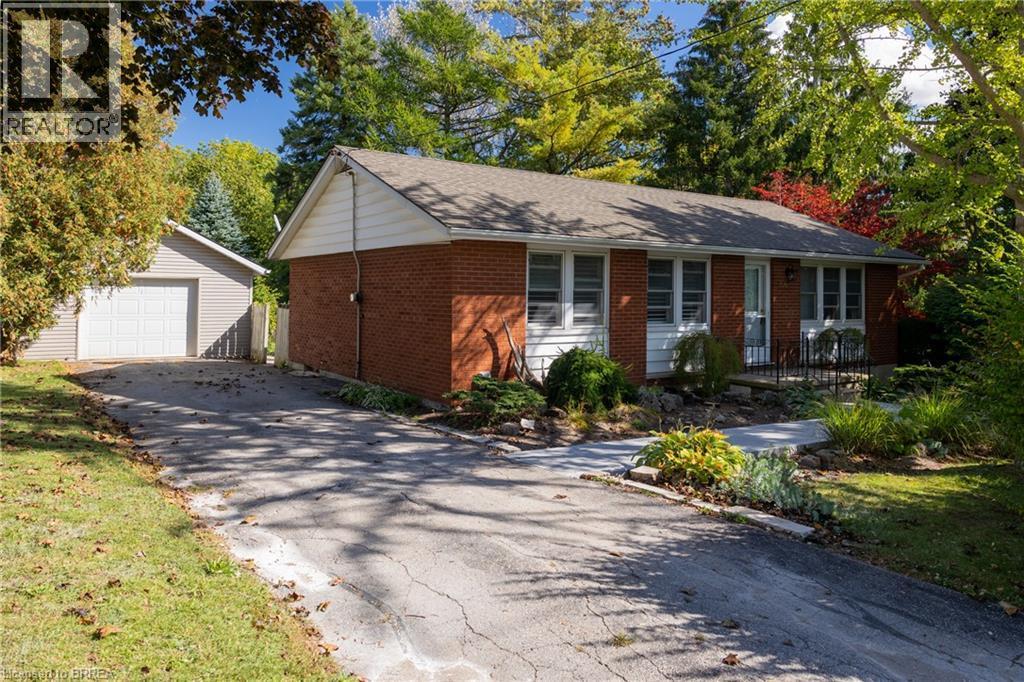 Brick ranch-style home featuring a covered front entrance and white window shutters - 156 Mutual Street N, Ingersoll, ON