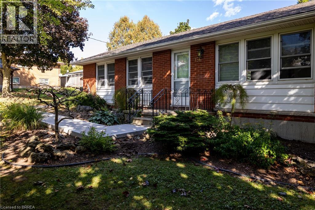 Expansive verdant lawn surrounded by mature trees and varied shrubbery - 156 Mutual Street N, Ingersoll, ON