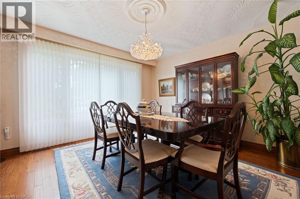 Dining area featuring wood-finish flooring, a decorative ceiling medallion, and a crystal chandelier - 7 Thomson Road, Simcoe, ON