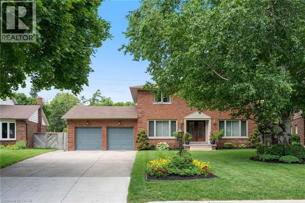 Brick exterior residence featuring a double-door entry, a two-car garage, and a concrete driveway - 7 Thomson Road, Simcoe, ON