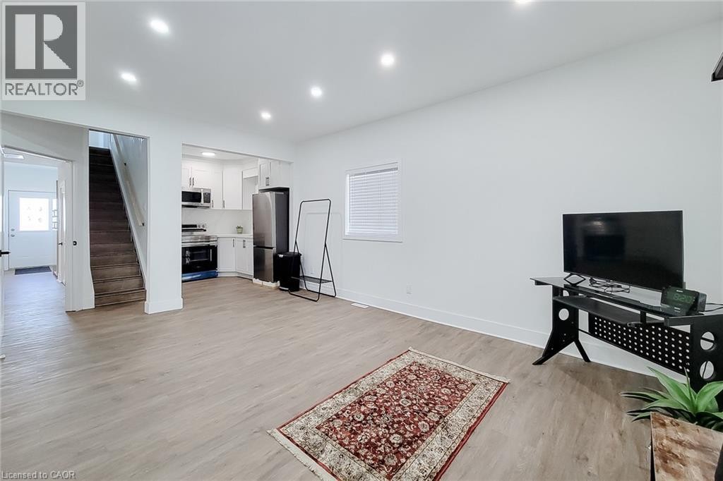 Open concept living area with wood-finish flooring, recessed lighting, and white baseboards - 78 Hillyard Street, Hamilton, ON