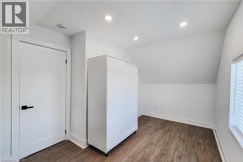Room featuring a sloped ceiling, wood-finish flooring, recessed lighting, and a window with blinds - 78 Hillyard Street, Hamilton, ON 