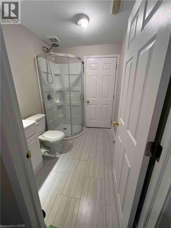 Bathroom featuring a corner shower enclosure with clear glass, a white toilet, and a white vanity with a cabinet - 151 Clairfields Drive E Unit# 4, Guelph, ON