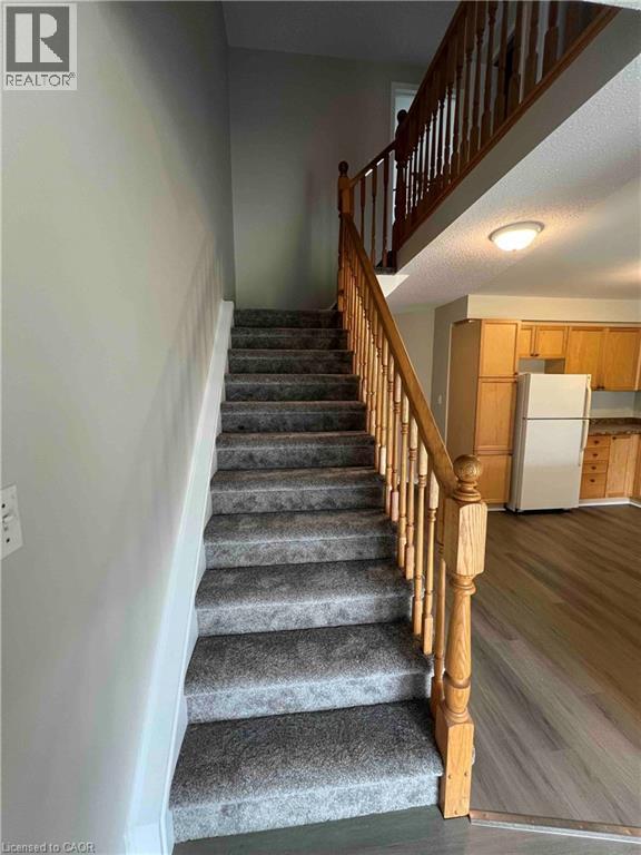 Carpeted staircase with wood balusters and handrail - 151 Clairfields Drive E Unit# 4, Guelph, ON
