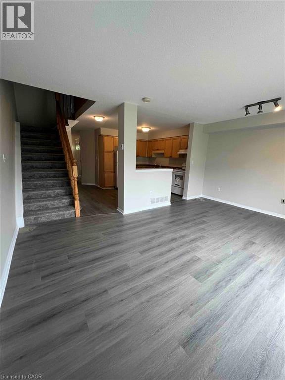 Spacious living area featuring contemporary wood-finish flooring - 151 Clairfields Drive E Unit# 4, Guelph, ON