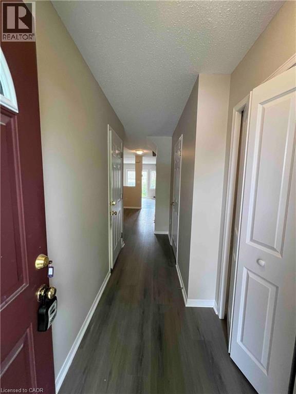 Entryway featuring a dark wood-finish floor and neutral wall tones - 151 Clairfields Drive E Unit# 4, Guelph, ON