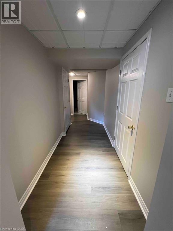 Hallway featuring wood-finish flooring, light gray walls, and white trim - 151 Clairfields Drive E Unit# 4, Guelph, ON