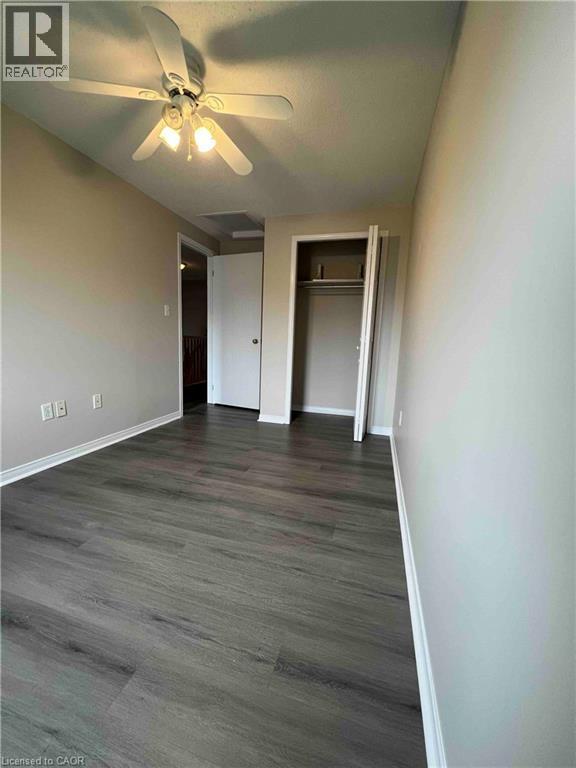 Room featuring wood-finish flooring, neutral wall tones, and a ceiling fan with integrated lighting - 151 Clairfields Drive E Unit# 4, Guelph, ON
