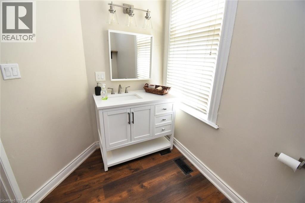 White vanity with brushed nickel hardware and a single-basin sink - 242 James Street S, Hamilton, ON
