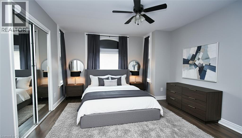 Bedroom featuring wood-finish flooring, light grey walls, and a ceiling fan with integrated lighting - 242 James Street S, Hamilton, ON
