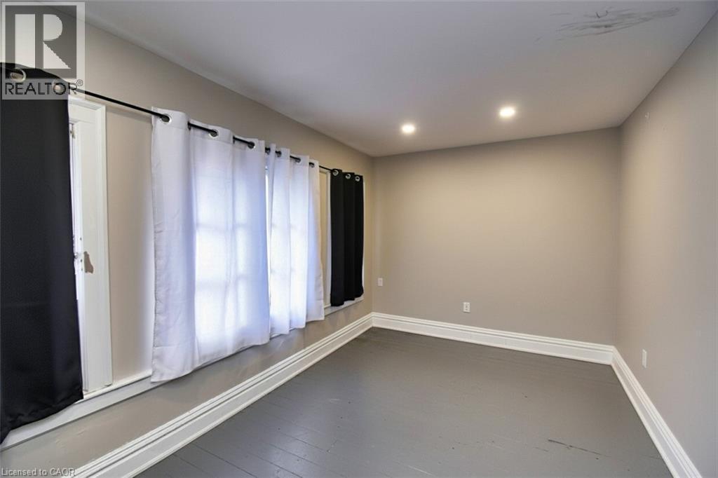 Room featuring painted flooring, neutral wall tones, and recessed ceiling lighting - 242 James Street S, Hamilton, ON