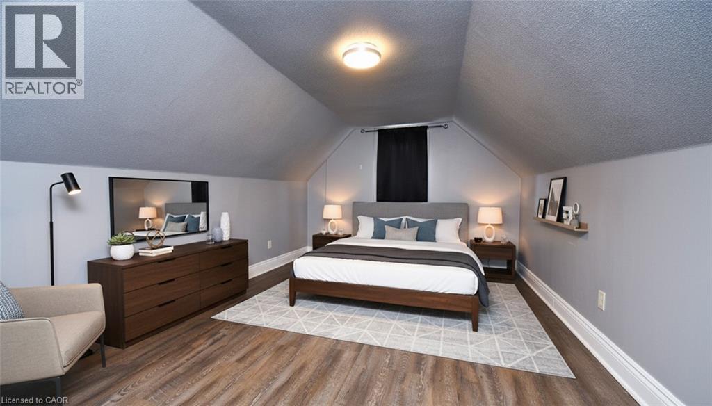 Attic space featuring wood-finish flooring, light grey walls, and a recessed ceiling light - 242 James Street S, Hamilton, ON